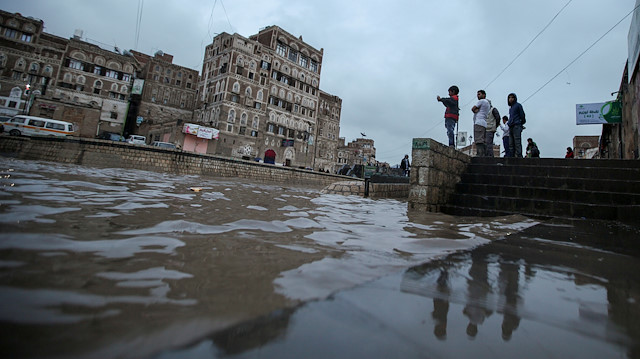 People look at the rising water level of floodwater during heavy rains in the old quarter of Sanaa, Yemen April 20, 2020