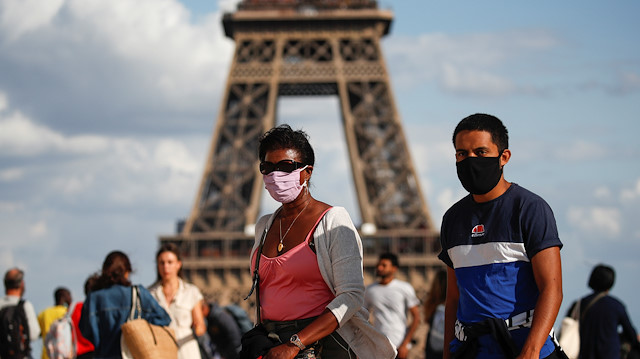 People wearing protective face masks walk at the Trocadero square near the Eiffel Tower in Paris as France reinforces mask-wearing as part of efforts to curb a resurgence of the coronavirus disease (COVID-19) across the country, August 3, 2020.