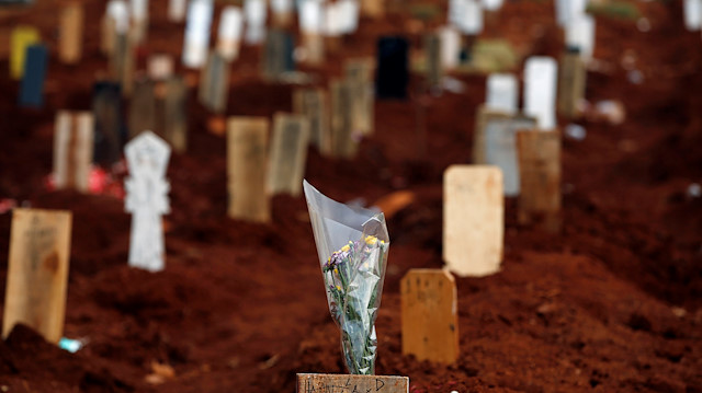 Flowers are placed on a grave at the Muslim burial area provided by the government for victims