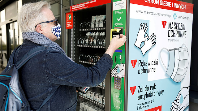 A man uses a vending machine for face masks