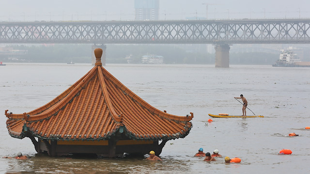 People swim near a pavilion partially submerged in floodwaters on the banks of the Yangtze River, following heavy rainfall in Wuhan, Hubei province, China July 8, 2020.