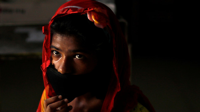 A girl wearing a protective face mask waits to be tested at a local health centre 