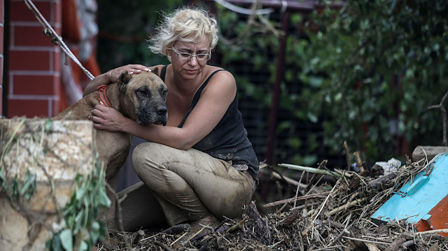 A woman hugs her dog at the village of Bourtzi, following flash floods on the island of Evia, Greece, August 9, 2020.