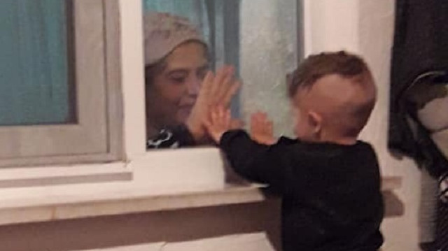Minik Ali Asaf, cam arkasından babaannesiyle oynamaya çalışıyor.  