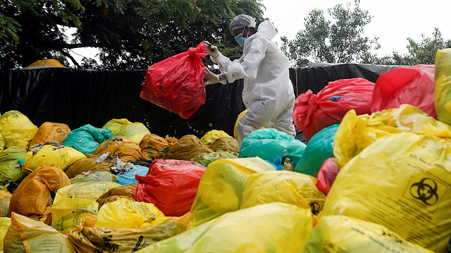 A man in personal protective equipment (PPE) clears bags filled with medical waste at a hospital, amidst the spread of the coronavirus disease (COVID-19) in Mumbai, India, August 11, 2020. REUTERS/Francis Mascarenhas


