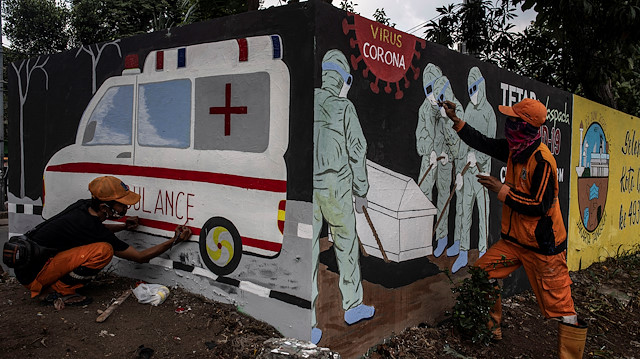 Workers paint a mural promoting coronavirus disease (COVID-19) awareness in Jakarta, Indonesia August 11, 2020.