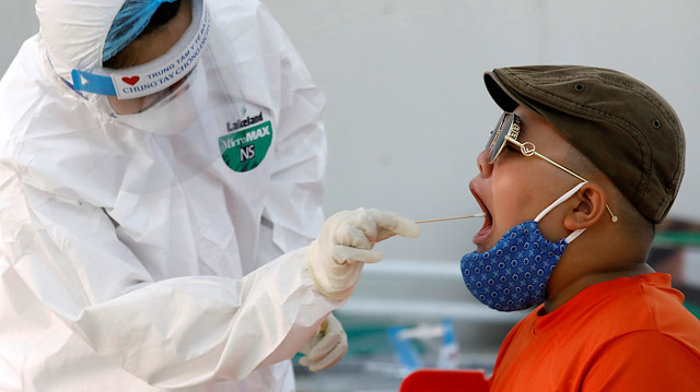File photo: A medical specialist wearing a protective suit collects a swab sample from a traveller who has returned from Da Nang, at a rapid testing center for coronavirus disease (COVID-19) in Hanoi, Vietnam August 8, 2020. REUTERS/Kham
