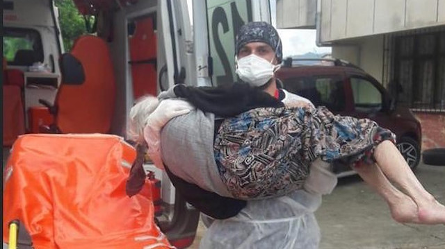 Sağlık çalışanı Uğur Hacıahmetoğlu evinde karantinaya alınacak yaşlı kadını kucağında taşıdı.