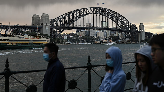 People walk in front of the Sydney Harbour Bridge as the state of New South Wales continues to report low numbers for new daily cases of the coronavirus disease (COVID-19) in Sydney, Australia, August 19, 2020. 