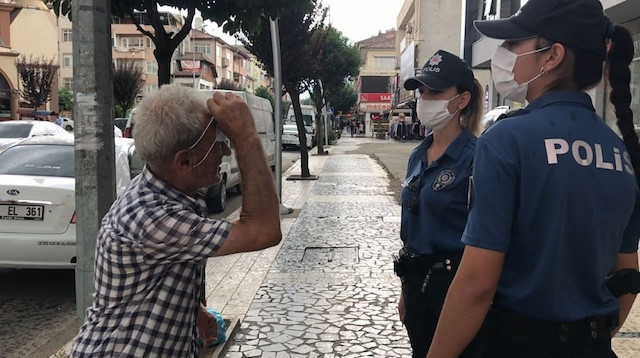 Yağmuru bahane ederek maskesini kafasına takana vatandaşı polisler uyardı. 