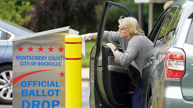 A woman reaches in to cast her ballot for Maryland's primary election at a drop box in Rockville, Maryland, U.S., June 2, 2020.