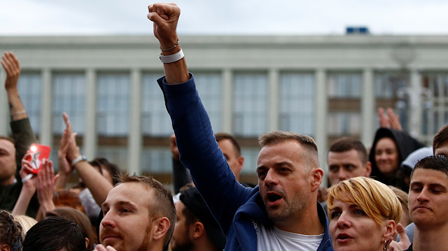 A man raises his fist as he attends an opposition demonstration to protest against presidential election results at the Independence Square in Minsk, Belarus, August 25, 2020.