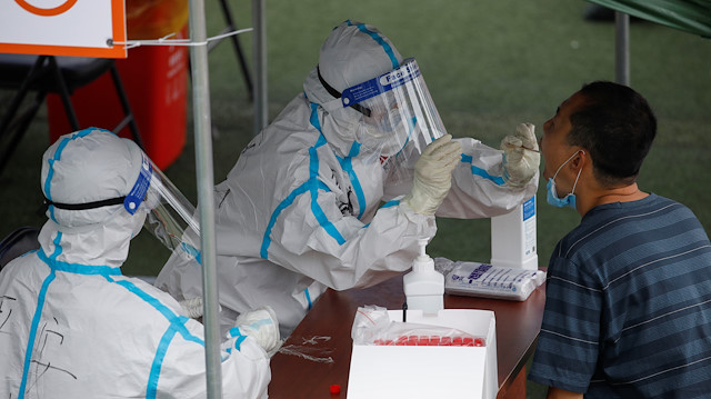 A medical worker in a protective suit conducts a nucleic acid test, during a government-organised visit to a testing site, following a new outbreak of the coronavirus disease (COVID-19) in Beijing, China June 24, 2020. 