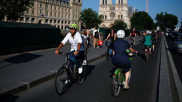 People ride bicycles near Notre Dame Cathedral during a warm and sunny day in Paris as a heatwave hits France, June 25, 2020