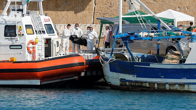 Emergency services carry a body at the dock of Le Castella after a migrant boat caught fire during rescue operations off the coast of Crotone, with some people still missing according to Italian media, Italy August 30, 2020. 