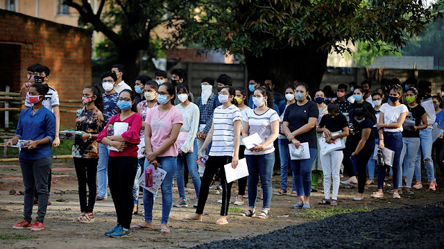 Students wearing protective face masks wait to enter an examination centre for Joint Entrance Examination (JEE), amidst the spread of the coronavirus disease (COVID-19), in Ahmedabad, India, September 1, 2020.