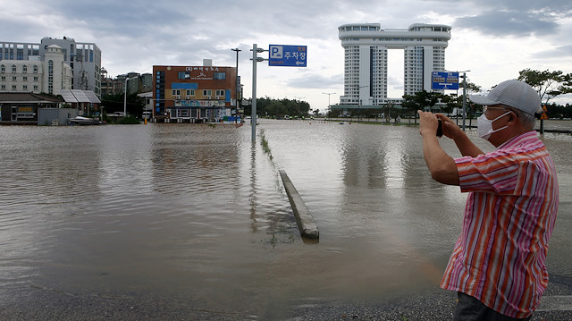 A man takes a photo of a submerged parking lot by Typhoon Maysak in Gangneung, South Korea, September 3, 2020. Yonhap via Reuters