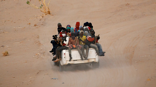 FILE PHOTO: Migrants crossing the Sahara desert into Libya ride on the back of a pickup truck outside Agadez, Niger, May 9, 2016.