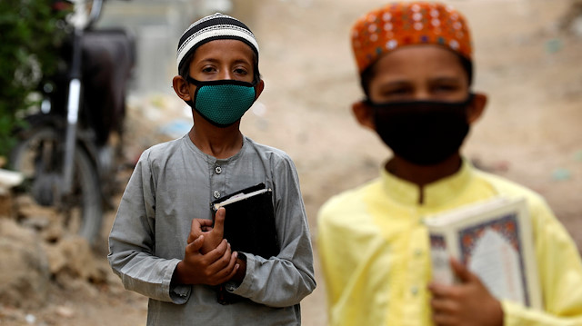 Boys wear protective masks as they head to the madrasa (religious school)