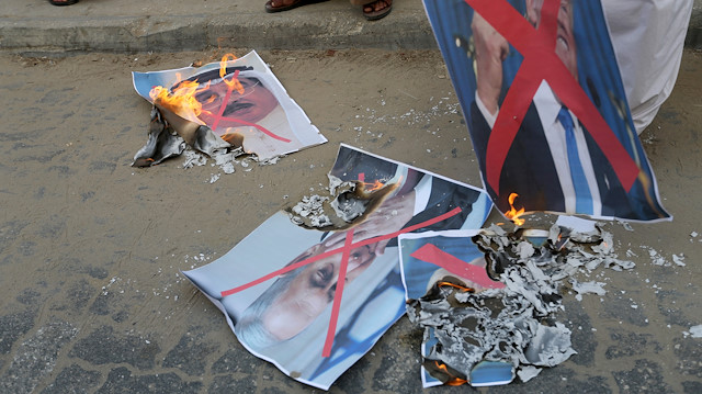 Palestinians burn pictures depicting U.S. President Donald Trump, Israeli Prime Minister Netanyahu