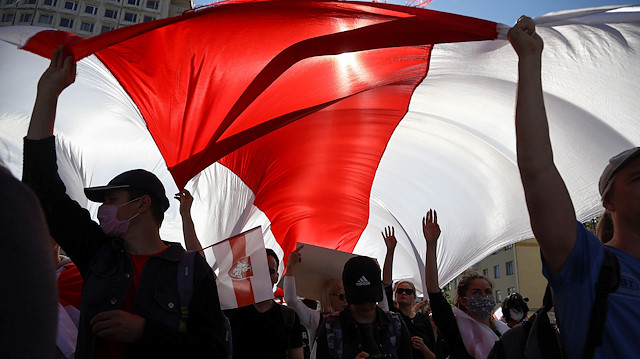 Opposition supporters carry a historical white-red-white flag of Belarus as they take part in a rally against police brutality following protests to reject the presidential election results in Minsk, Belarus September 13, 2020. Tut.By via REUTERS REUTERS 