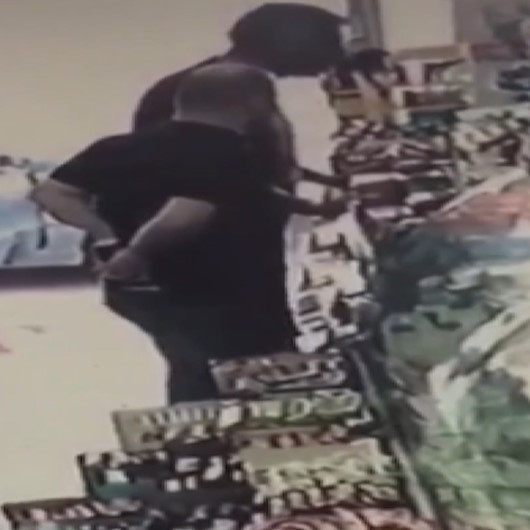 Alkol kutusunu pantolonunun arkasına sokup çalan hırsız kamerada