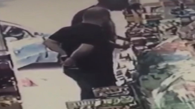 Alkol kutusunu pantolonunun arkasına sokup çalan hırsız kamerada