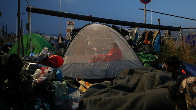 A woman is seen inside a tent as refugees and migrants from the destroyed Moria camp sleep, near a new temporary camp, on the island of Lesbos, Greece, September 14, 2020. 