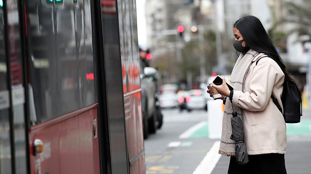 A person wearing a face mask boards a bus on the first day of New Zealand's new coronavirus disease (COVID-19) safety measure that mandates wearing of a mask on public transport, in Auckland, New Zealand, August 31, 2020. 
