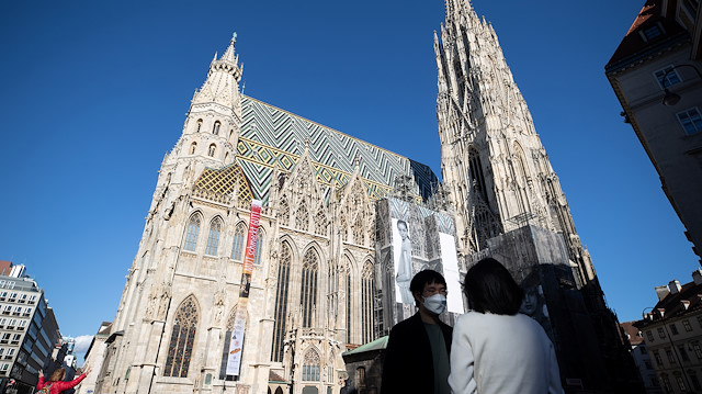 A tourist wears a protective mask in front of St. Stephen's Cathedral (Stephansdom) in Vienna, Austria March 13, 2020. REUTERS/Lisi Niesner

