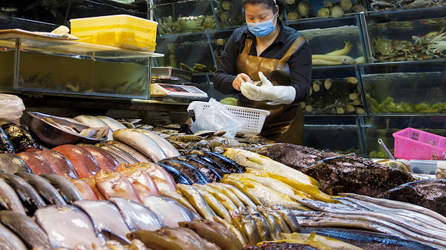 A woman works at a fish and seafood stall at a wet market following an outbreak of the coronavirus disease (COVID-19) in Beijing, China, August 14, 2020. REUTERS/Thomas Peter

