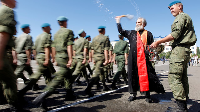 FILE PHOTO: An Orthodox priest blesses Russian paratroopers marching during Paratroopers' Day celebrations, the annual holiday of Russian Airborne Troops, at their military unit in the southern city of Stavropol, Russia, August 2, 2017. REUTERS/Eduard Korniyenko TPX IMAGES OF THE DAY/File Photo

