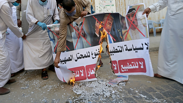 FILE PHOTO: Palestinians burn pictures depicting Israeli Prime Minister Benjamin Netanyahu, Abu Dhabi Crown Prince Mohammed bin Zayed al-Nahyan, Ruler of Dubai Sheikh Mohammed bin Rashid al-Maktoum, Bahrain's King Hamad bin Isa Al Khalifa and U.S. President Donald Trump during a protest against Bahrain's move to normalize relations with Israel, in the central Gaza Strip September 12, 2020. REUTERS/Ibraheem Abu Mustafa/File Photo
