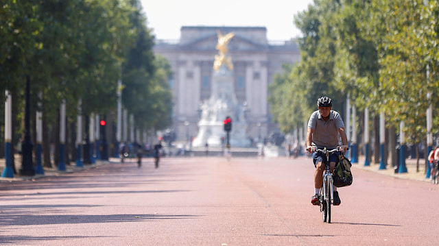 FILE PHOTO: A man cycles down The Mall, with Buckingham Palace in the background, in London, Britain, August 9, 2020. 