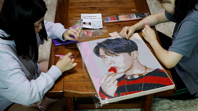 Kim Seo-hyeon, a fan of K-pop boy band BTS, works on a mosaic depicting band member J-Hope with her sister at their home in Seoul, South Korea, September 23, 2020. Picture taken September 23, 2020. REUTERS/Kim Hong-Ji

