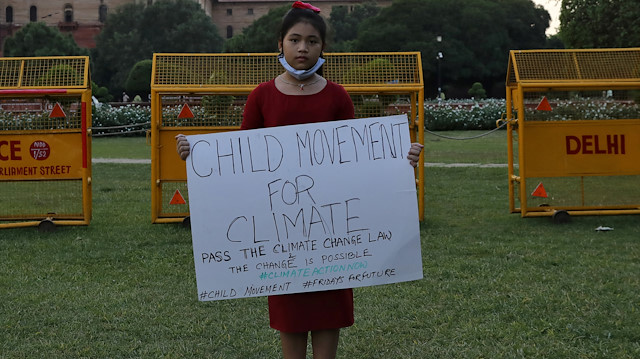 Licypriya Kangujam, 8, India's young climate activist, holds a poster during a protest demanding to pass a climate change law outside the parliament in New Delhi, India, September 23, 2020. Picture taken September 23, 2020. REUTERS/Anushree Fadnavis