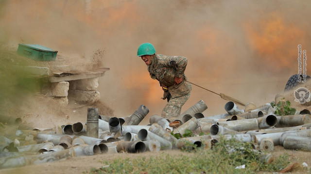 An ethnic Armenian soldier fires an artillery piece during fighting with Azerbaijan's forces in the breakaway region of Nagorno-Karabakh, in this handout picture released September 29, 2020. Defence Ministry of Armenia/Handout via REUTERS