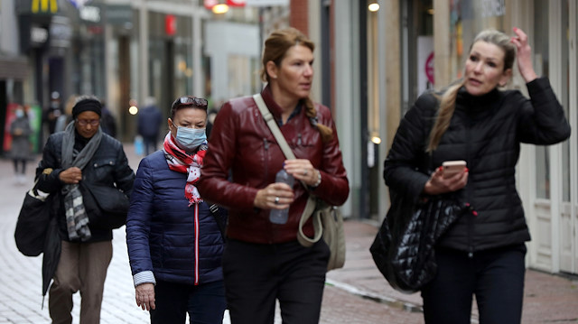 People with and without protective masks walk through the shopping street as the spread of coronavirus disease (COVID-19) continues in Amsterdam, Netherlands October 7, 2020. 