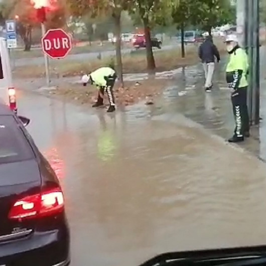 Polis memurları, tıkanan rögarı elleriyle açmaya çalıştı