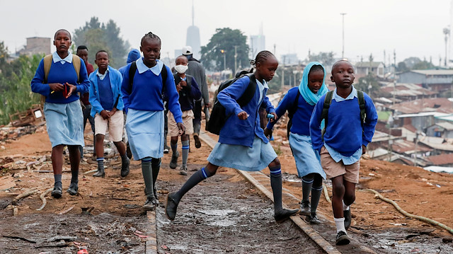 School children walk along the Kenya-Uganda railway line during the partial reopening of schools, after the government scrapped plans to cancel the academic year due to the coronavirus disease (COVID-19) pandemic, in Kibera slums of Nairobi, Kenya October 12, 2020.