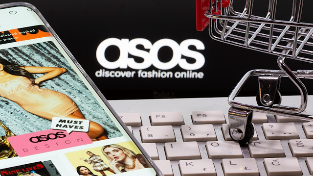 Smartphone with ASOS app, a keyboard and a shopping cart are seen in front of a displayed ASOS logo in this illustration picture taken October 13, 2020. REUTERS/Dado Ruvic/Illustration

