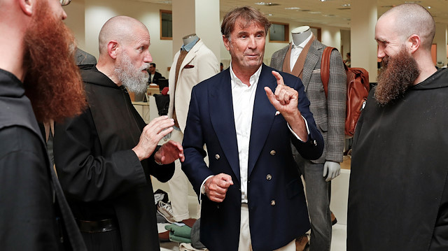 Italian fashion tycoon Brunello Cucinelli chats with monks before a presentation of a newly restored medieval hamlet and valley at his company headquarters in Solomeo village near Perugia, Italy, September 4, 2018. Picture taken September 4, 2018. REUTERS/Alessandro Bianchi

