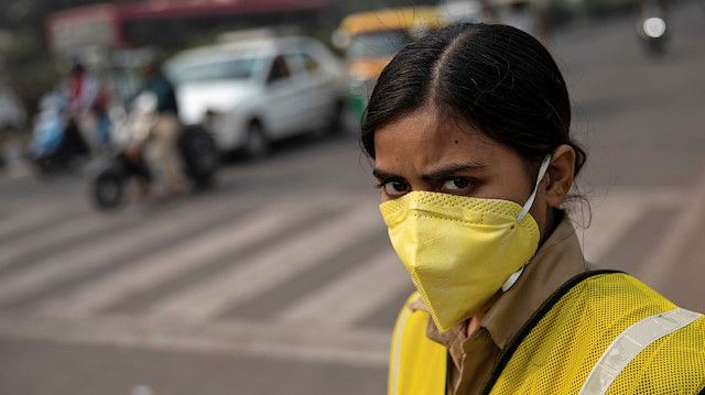 A policewoman wears a mask to protect herself from air pollution at a junction during restrictions on private vehicles based on registration plates on a smoggy morning in New Delhi, India, November 4, 2019