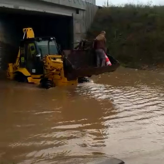 Su basan alt geçitte aracıyla mahsur kalan taksici, kepçeyle kurtarıldı