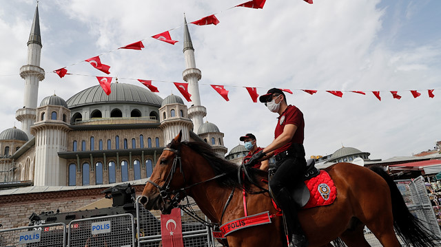 Members of Istanbul Police Department Mounted Unit patrol against people not wearing protective face masks at Taksim Square 
