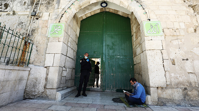 A Muslim worshipper reads the Koran at the entrance to the compound known to Muslims as al-Haram al-Sharif and to Jews as Temple Mount hosting Al-Aqsa mosque Jerusalem's Old City, amid coronavirus disease (COVID-19) restrictions May 8, 2020 REUTERS/ Ammar Awad

