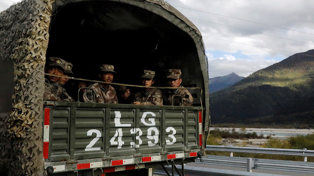 Chinese soldiers of the People's Liberation Army (PLA) sit on the back of a truck on the highway to Nyingchi, Tibet Autonomous Region, China, October 19, 2020. REUTERS/Thomas Peter

