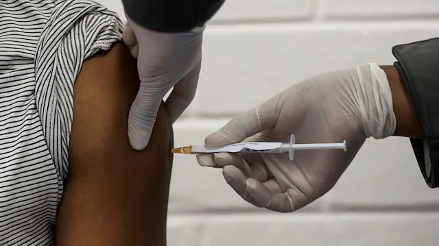 A volunteer receives an injection from a medical worker during the country's first human clinical trial for a potential vaccine against the novel coronavirus, at the Baragwanath hospital in Soweto, South Africa, June 24, 2020.
