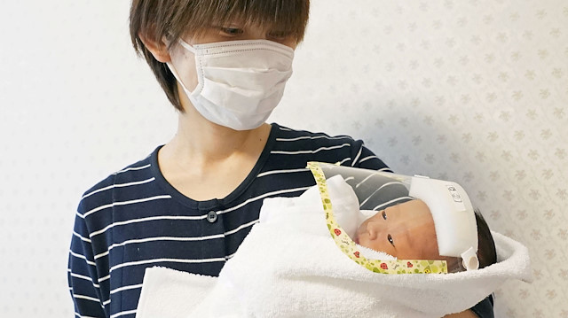 Mika Chiba and her newborn baby wearing a face shield