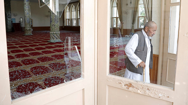 A man walks at a damaged mosque after a blast in Kabul, 